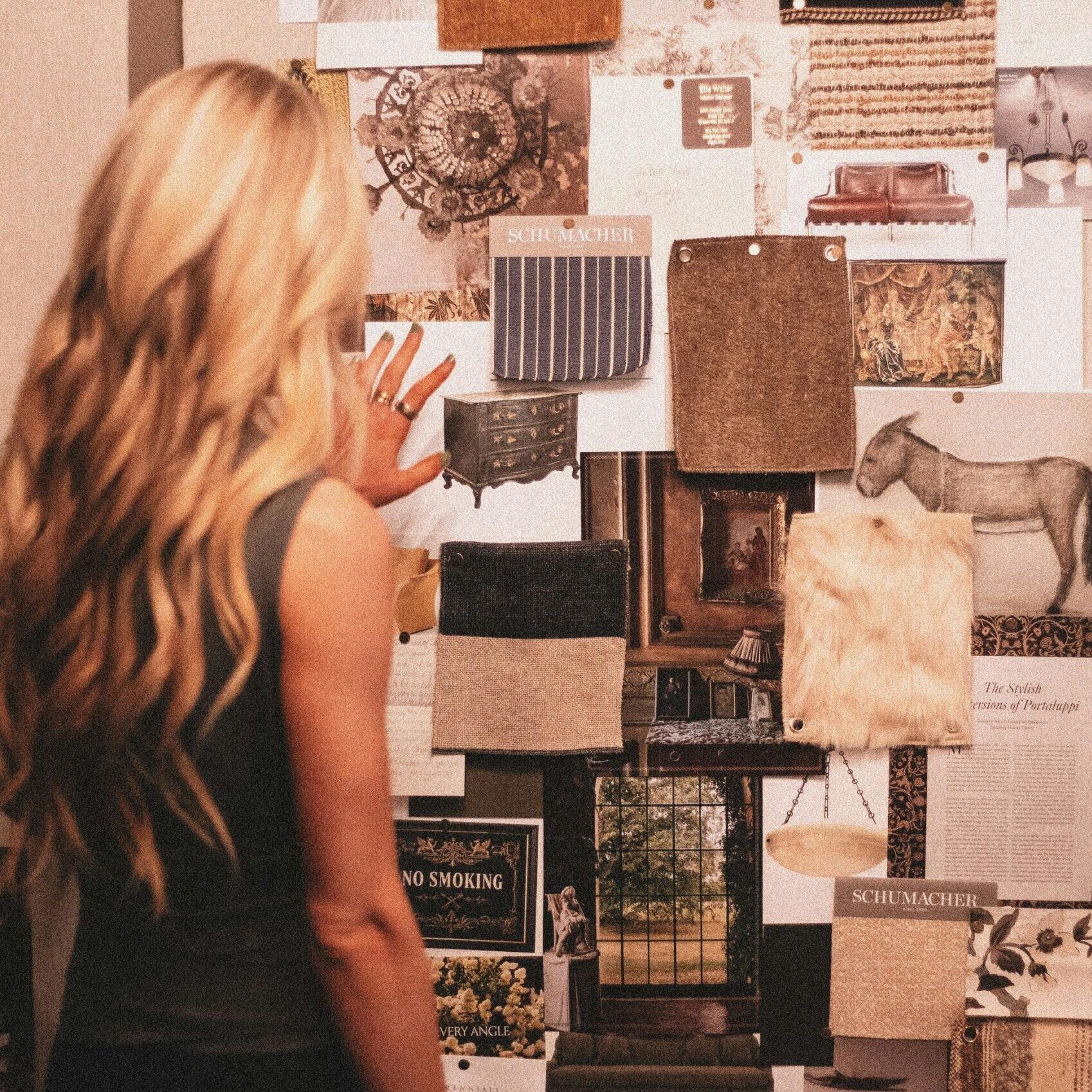 A woman explores a mood board filled with textures and design inspirations, blending classic and modern tastes.
