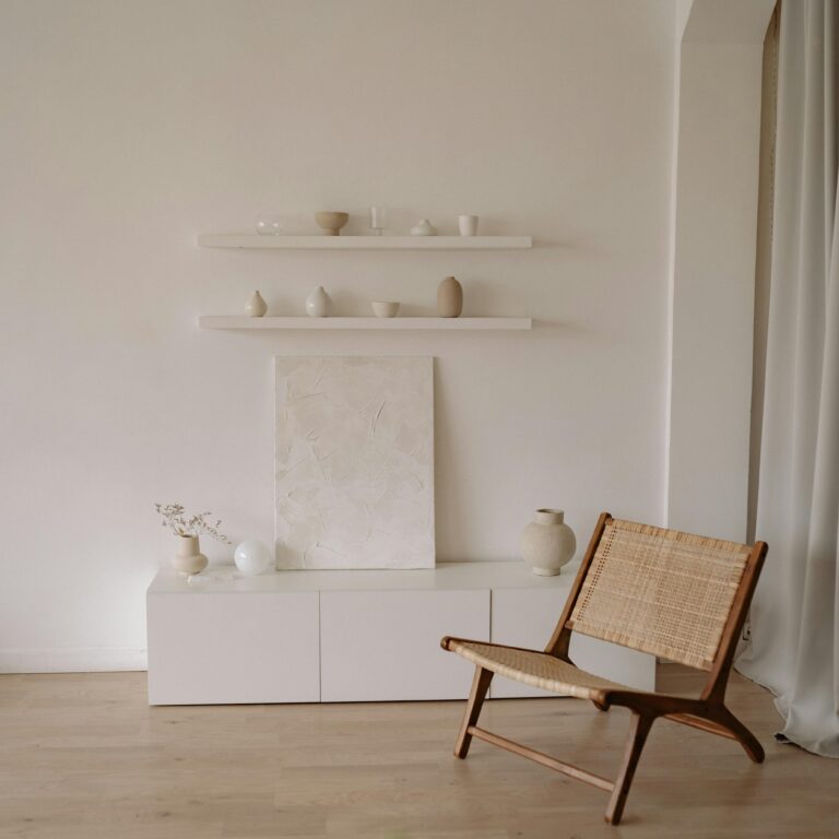 Elegant minimalist living room featuring a wicker chair and neutral decor elements.